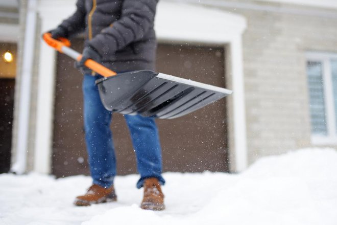 Tudi če se boste snega hoteli znebiti čim hitreje, na lopato ne nalagajte prevelike teže. FOTO: Maria Sbytova/Shutterstock
Foto: