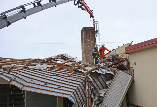 Zaradi nujnih posegov intervencijskih ekip, ki po neurju odstranijo nevarne dele strehe, je težko natančno ugotoviti napake na njej. Foto: Tadej Regent
Foto: