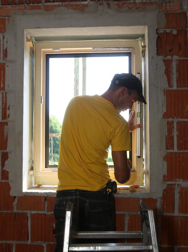 Monter je okno pritrdil ob špalete z lesenimi zagozdami, podstavil trajne podložke pod okvir in distančnike ob strani, vodoraven položaj pa ob vsaki spremembi preveril z libelo. 
Foto: