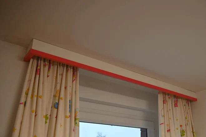Tako montirana karnisa blokira prehajanje zraka iznad radiatorja v prostor. Posledica je plesen na prekladi. Rešitev pa je preprosta: med karniso in strop vstavimo petcentimetrski distančnik na vijake. Foto Bojan Žnidaršič