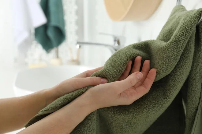 Po uporabi brisačo takoj obesite na široko, najbolje na zračno mesto ali neposredno pod ventilator ali okno. Foto New Africa//Shutterstock
