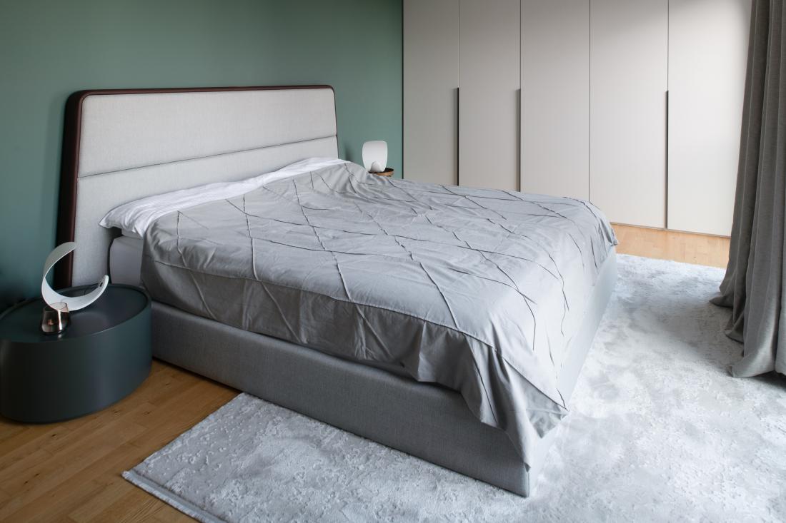Temno zelena barva v spalnici za posteljo je protiutež steklenim površinam nasproti postelje.