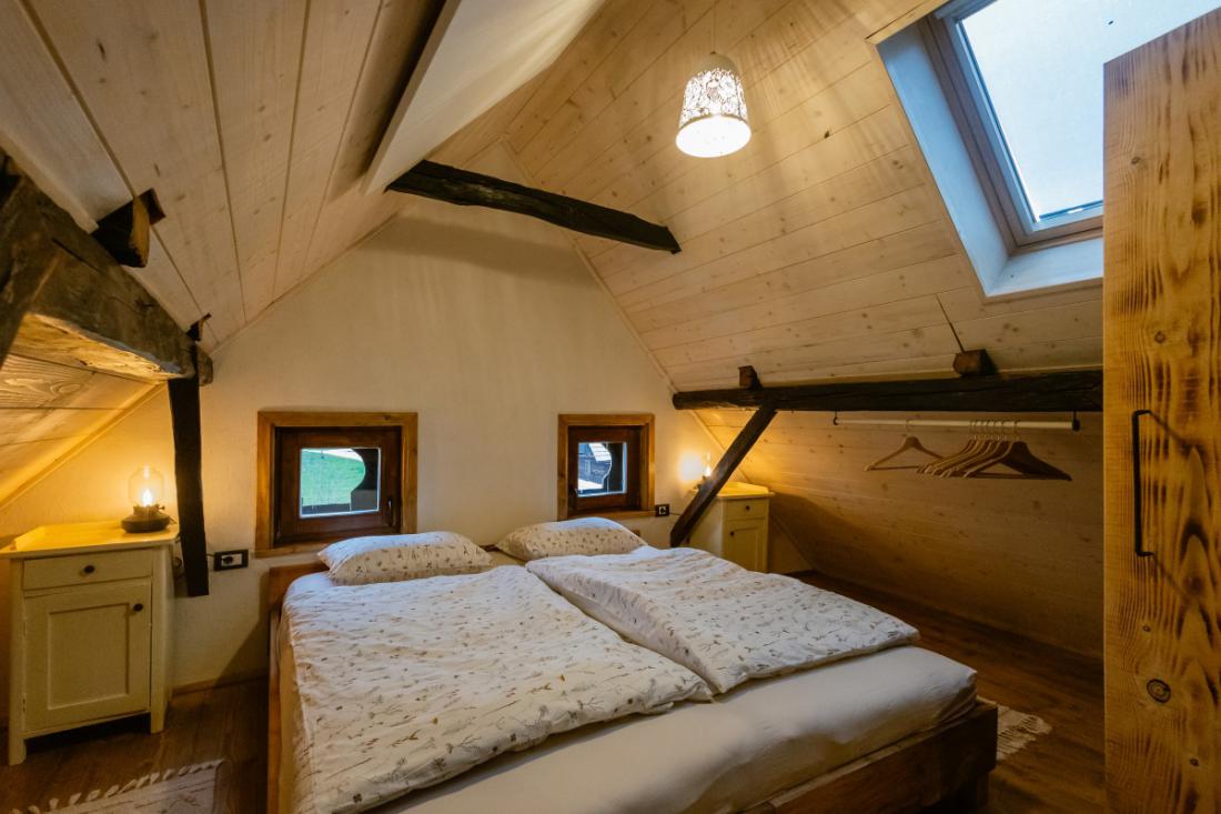 Prostorno podstrešje je namenjeno udobnima spalnicama, ki sta opremljeni z obnovljenim starinskim pohištvom. FOTO: Črt Piksi