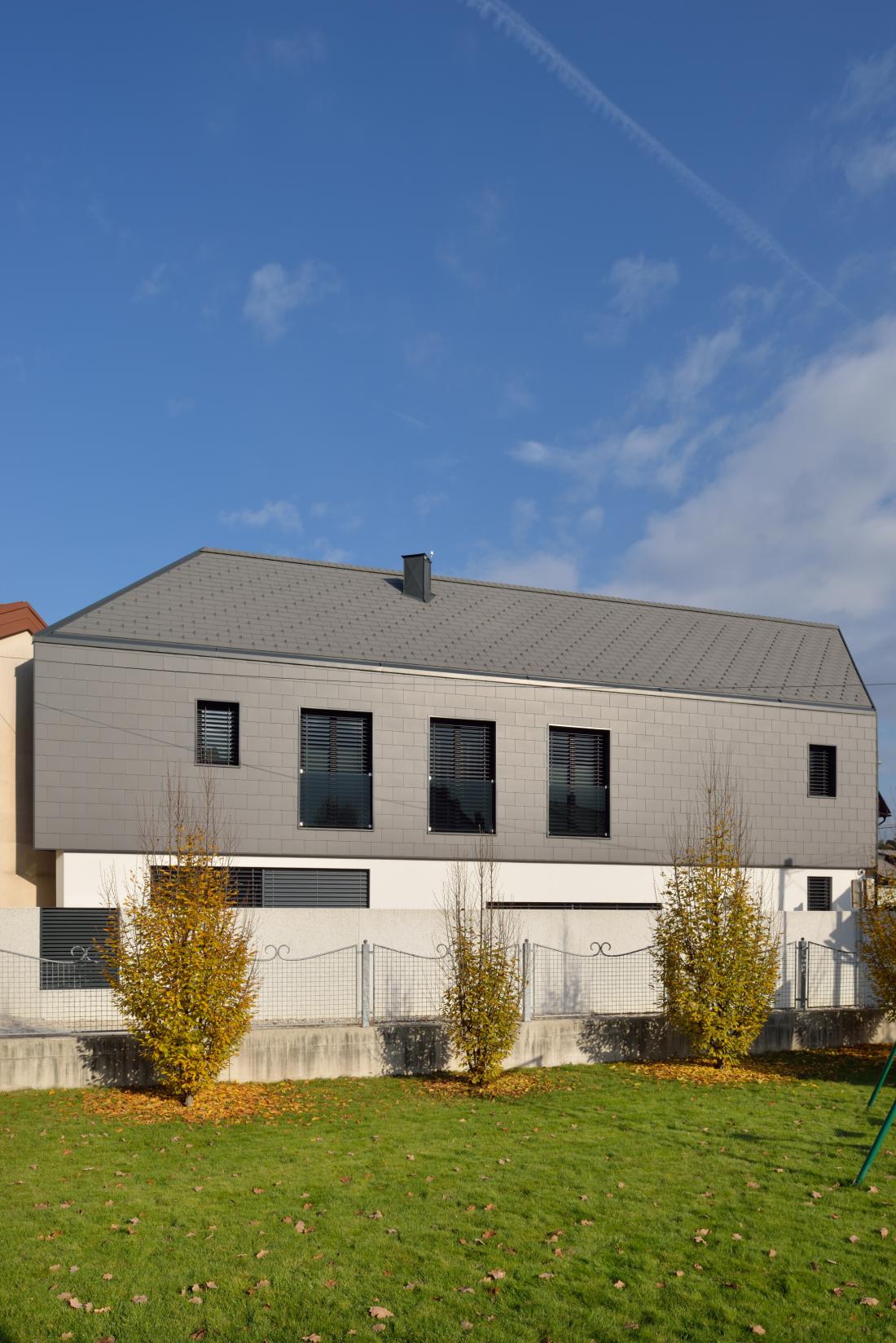 Vedno več je projektov, kjer se ravna kritina iz strehe nadaljuje tudi na fasado. Foto: Swisspearl
