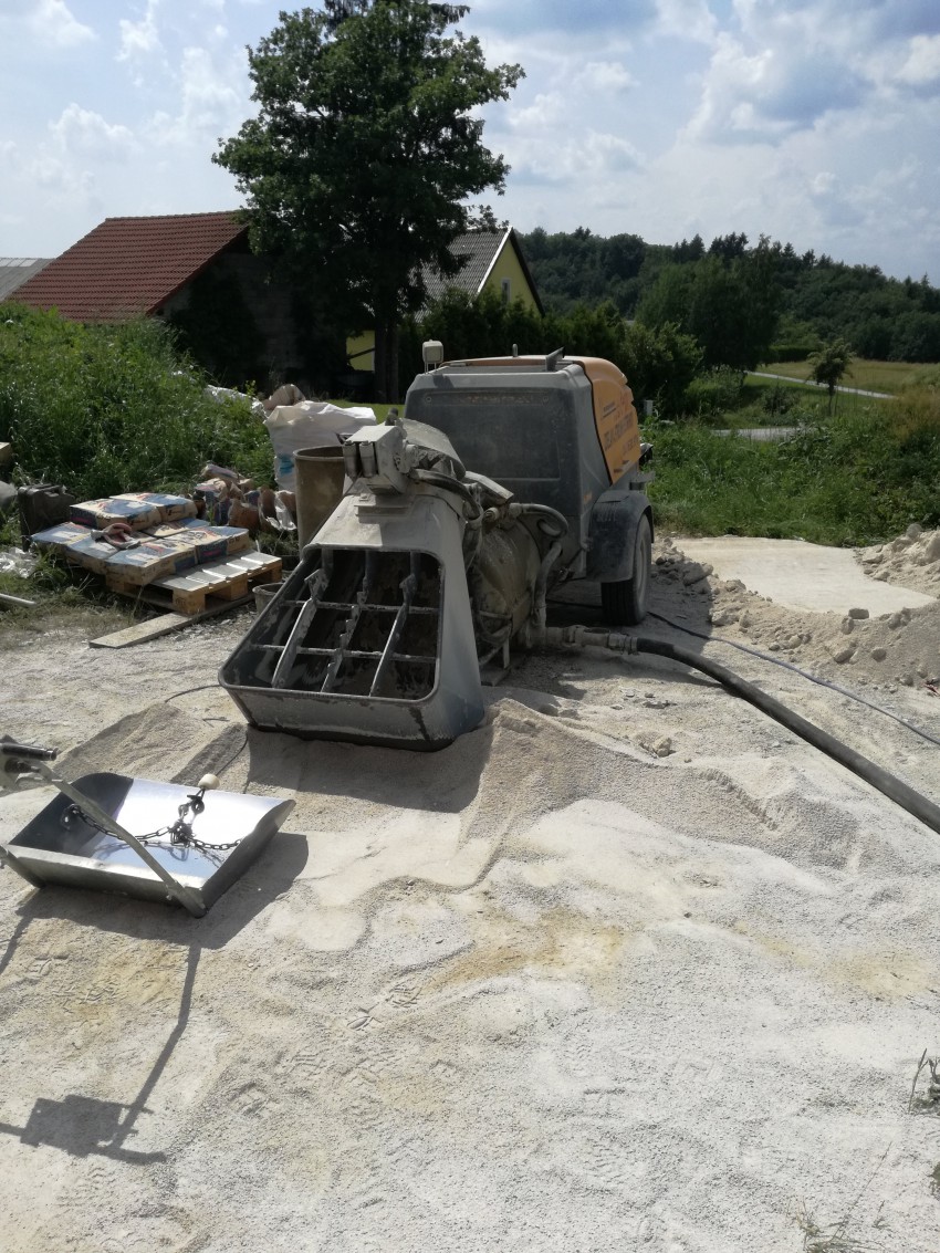 Požiralec peska in cementa, ki je opravil vso težaško delo, mešanje in črpanje zmesi v hišo.