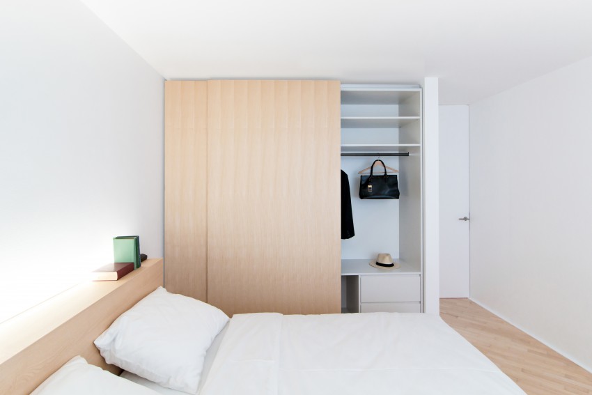 V glavni spalnici prevladujejo toplejši odtenki lesa, iz katerega so izdelane omare in postelja.