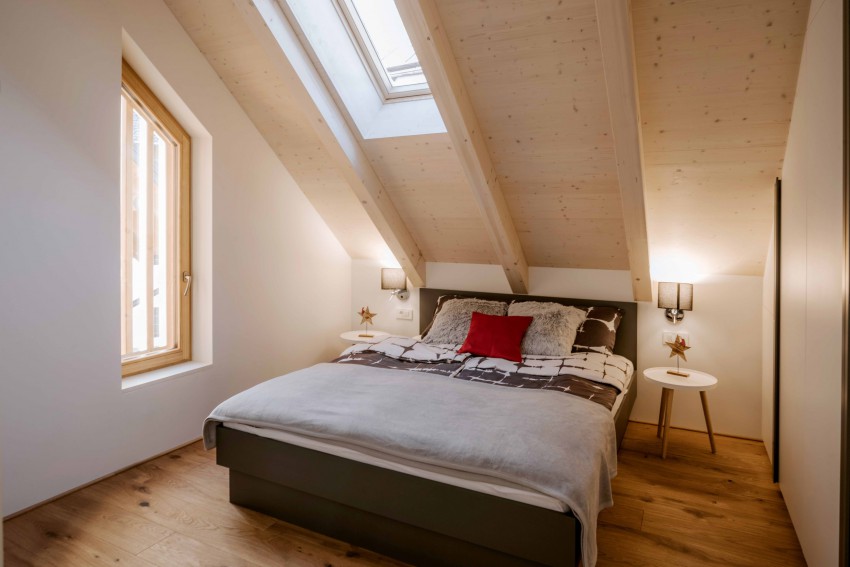 Tudi spalnico zaznamujejo vidni leseni tramovi.