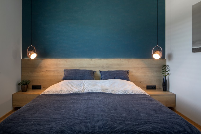 <p>V spalnici ob postelji so namesto dveh namiznih svetil umestili viseči, ki sta vpeti v strop.</p>