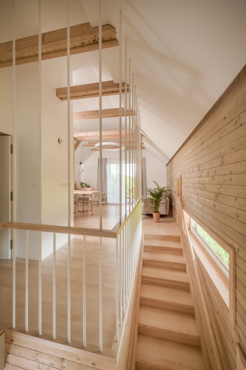 <p>Ograjo stopnic sestavljajo bele kovinske vertikale, ki dopolnjujejo les na steni in tleh ter prepuščajo poglede.</p>
