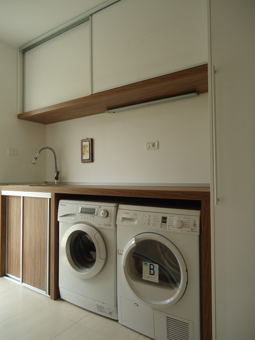 Po meri narejena pralnica v kombinaciji bele barve in lesnega dekorja. 