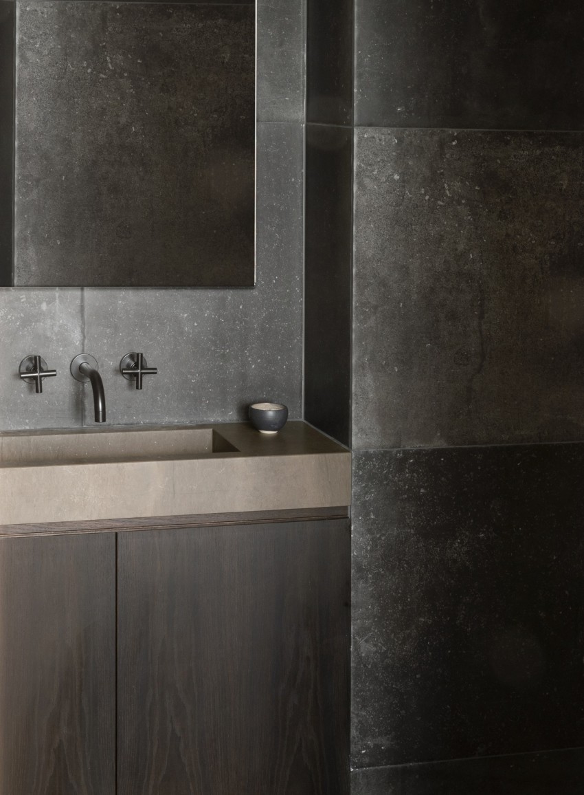 <p>Svinčeno sive kamnite obloge – kopalnica deluje kot skalna votlina.</p>