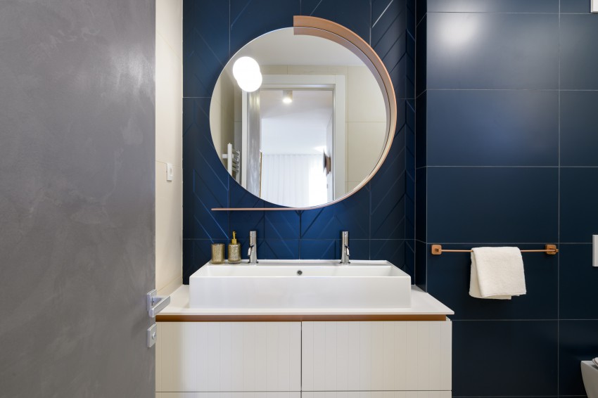 <p>Dramatičnost v kopalnici ustvarjajo keramične ploščice v temno modri barvi.</p>