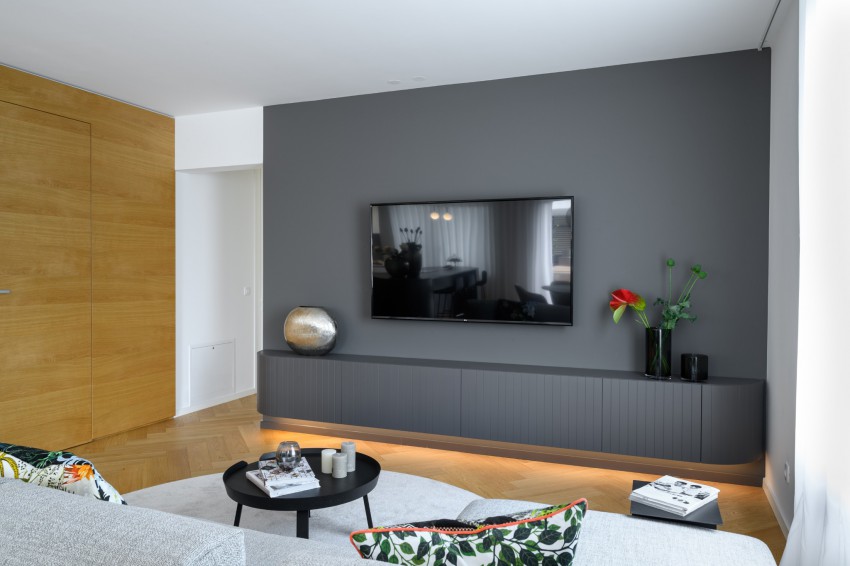 <p>Kombinacija sive barve, lesa in mehkih tkanin ustvarja topel interier.</p>