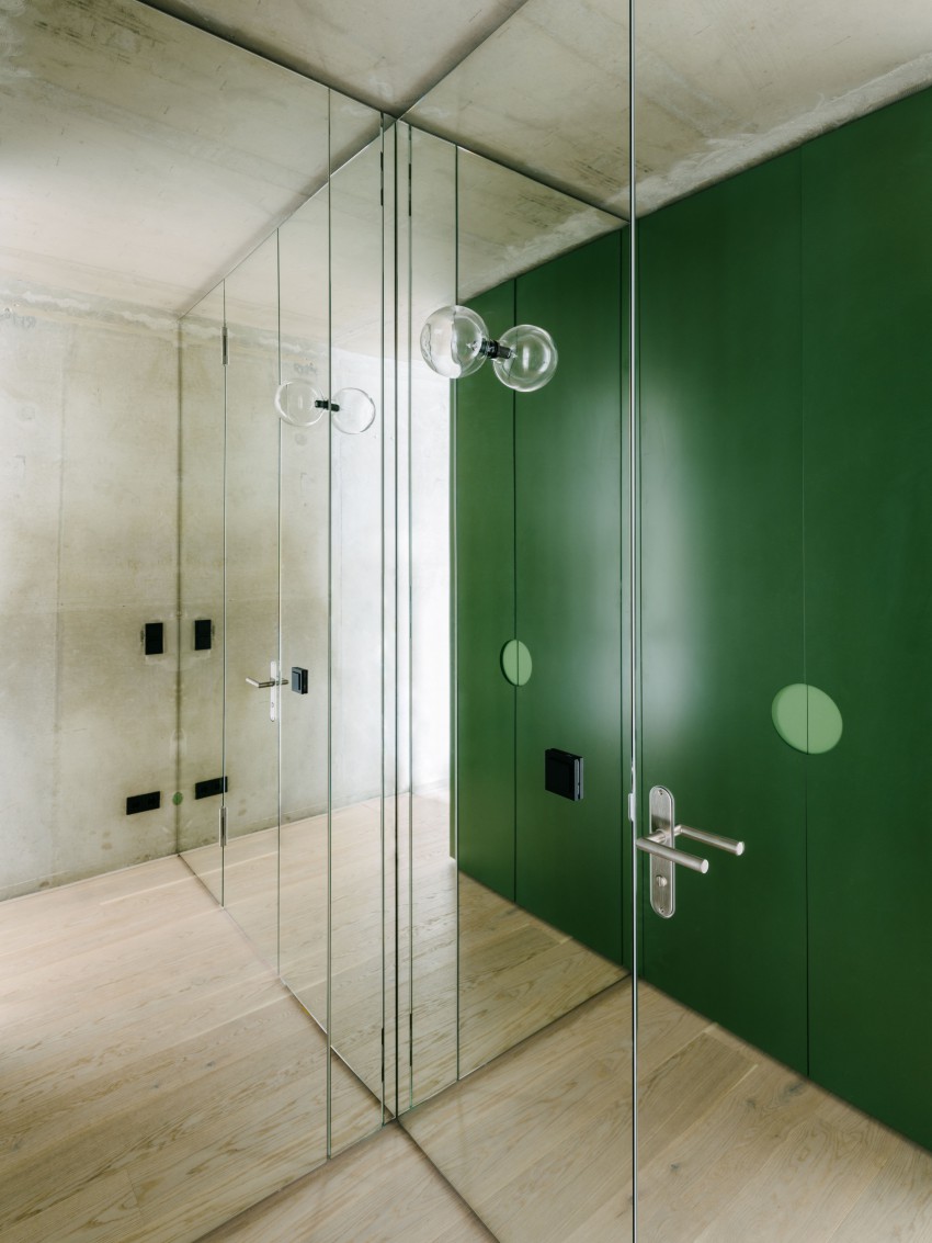 <p>Eno steno so oblekli v ogledala, v katerih odseva zelena barva.</p>