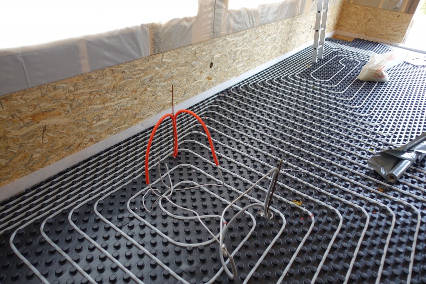 Cevi toplovodnega talnega gretja se polagajo v sistemske plošče z vodili. Po testiranju vodotesnosti jih prekrije betonski estrih. Možna je tudi suho montažna izvedba. 