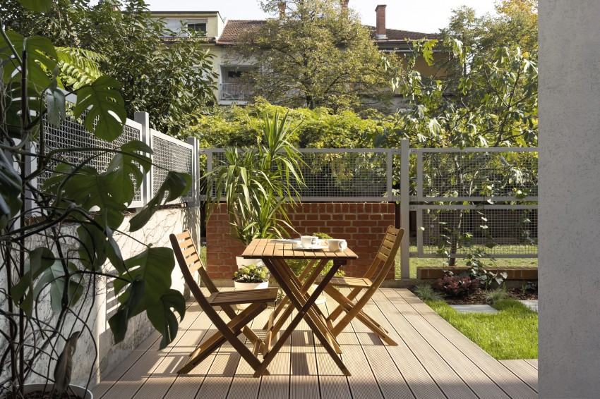 Zunaj so uporabljeni naravni materiali: miza in stoli so leseni ter se lepo ujemajo z zelenjem v okolici.