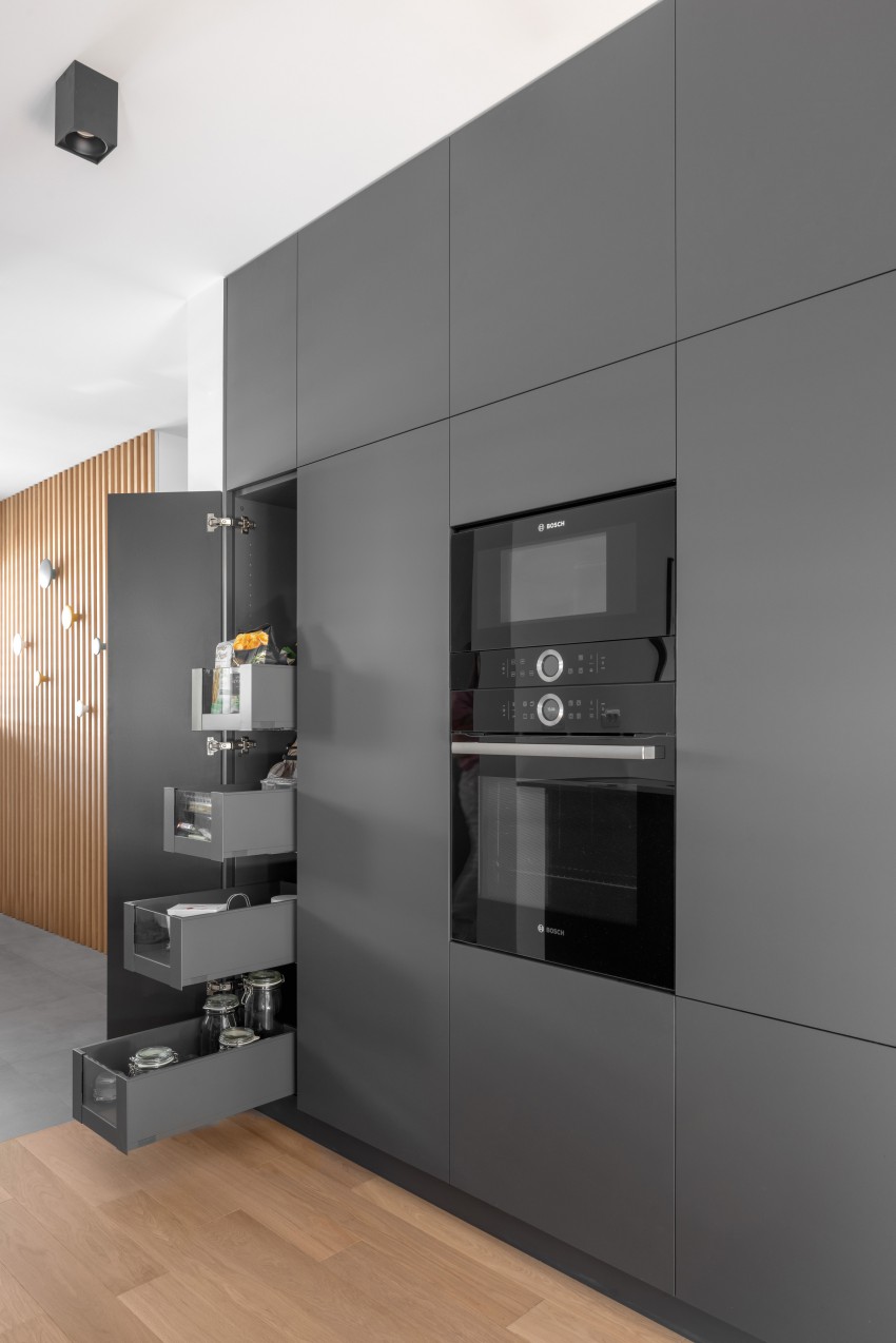 Na eni strani kuhinje je niz visokih elementov, v katerih se skrivajo shramba, pečici in dva hladilnika.